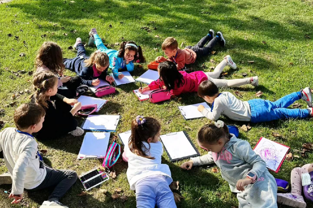 Abaküs Anaokulu ile oyun temelli öğrenme modeli Yere uzanarak boyama kitabına boyama yapan çocuklar